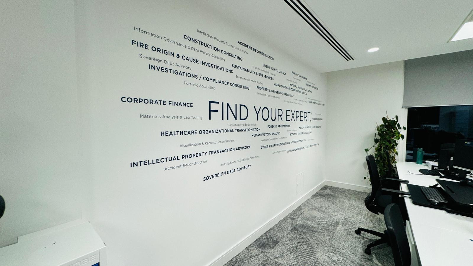 An office wall graphic of buzzwords surrounding the main phrase of "FIND YOUR EXPERT."